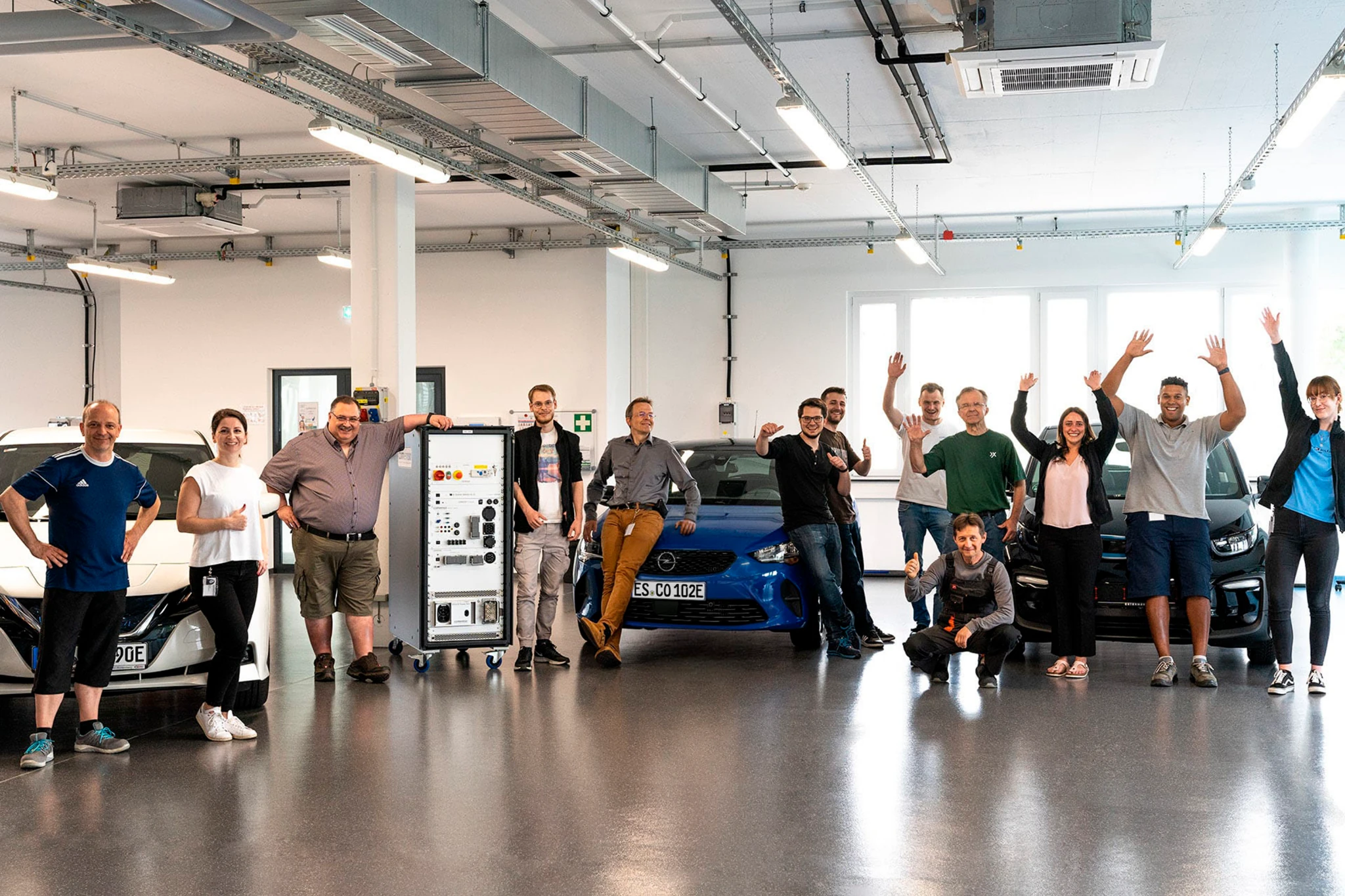 Das comemso-Team mit Elektrofahrzeugen und Ladeprüftechnik im Labor