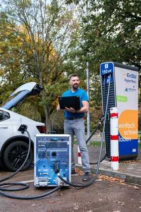 EVCA Multi Mobile portable test setup beside an electric vehicle and charging station